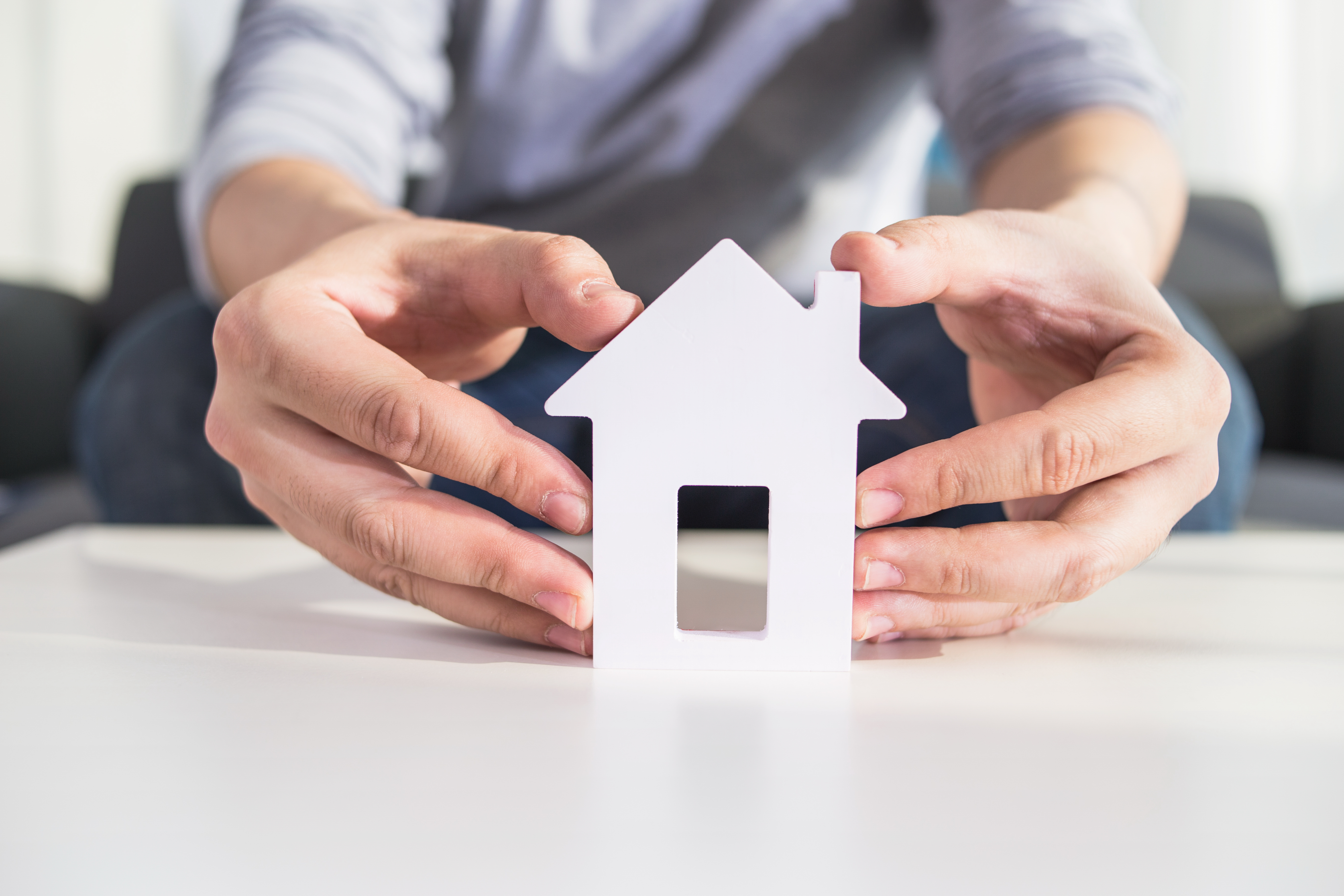 businessmen hold house model in hand